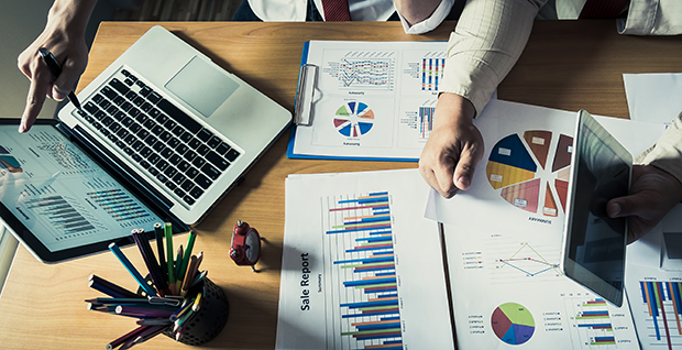 Business people in a meeting using Minitab's statistical and predictive analytic solutions to analyze financial data.