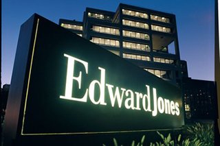 Lit up Edward Jones Office entrance sign outside of the office at dusk.