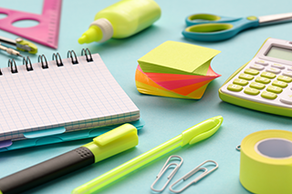 Collection of school supplies on a blue paper background.