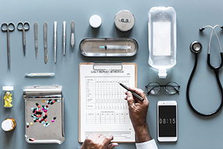 Medical equipment laid out with someone marking things off a checklist