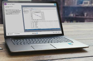 Laptop on a table displaying graphs from Minitab's statistical software.