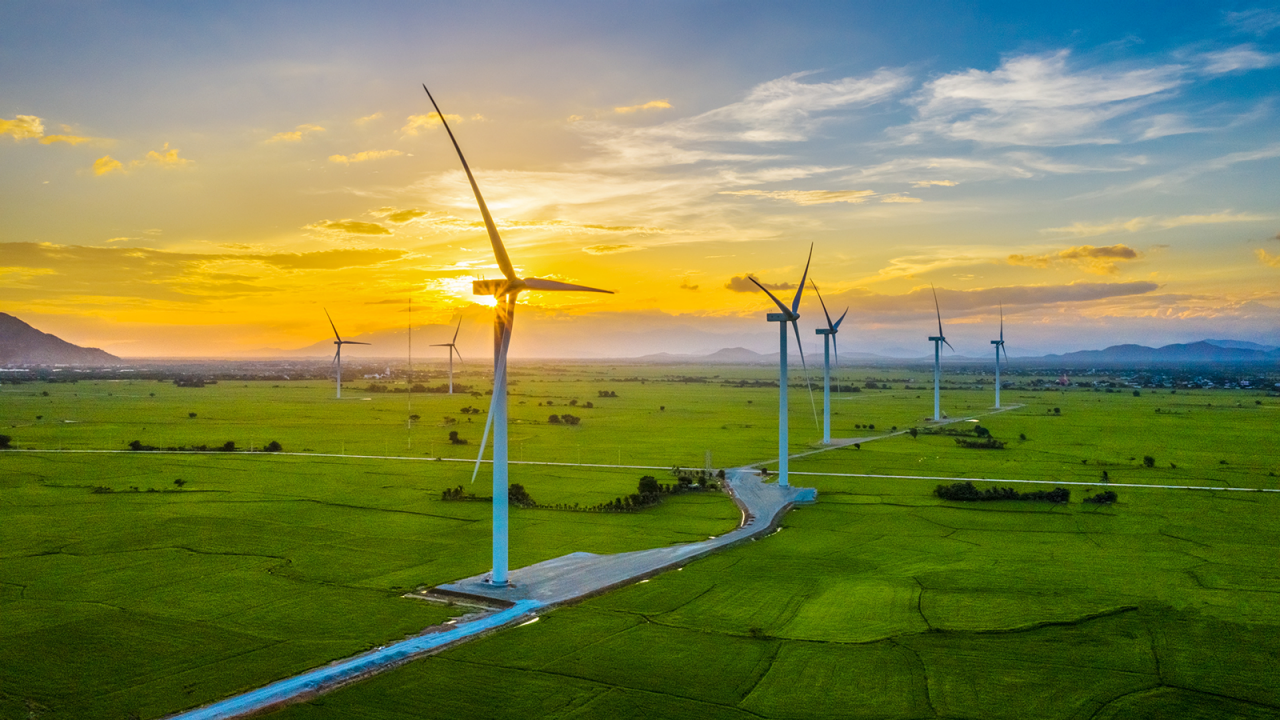 Landschaft mit Windrädern, grüne Energie, Windkraftanlagen für die Stromproduktion, Windenergieanlagen produzieren Strom auf einem Reisfeld in Phan Rang, Ninh Thuan, Vietnam. Konzept für saubere Energie.