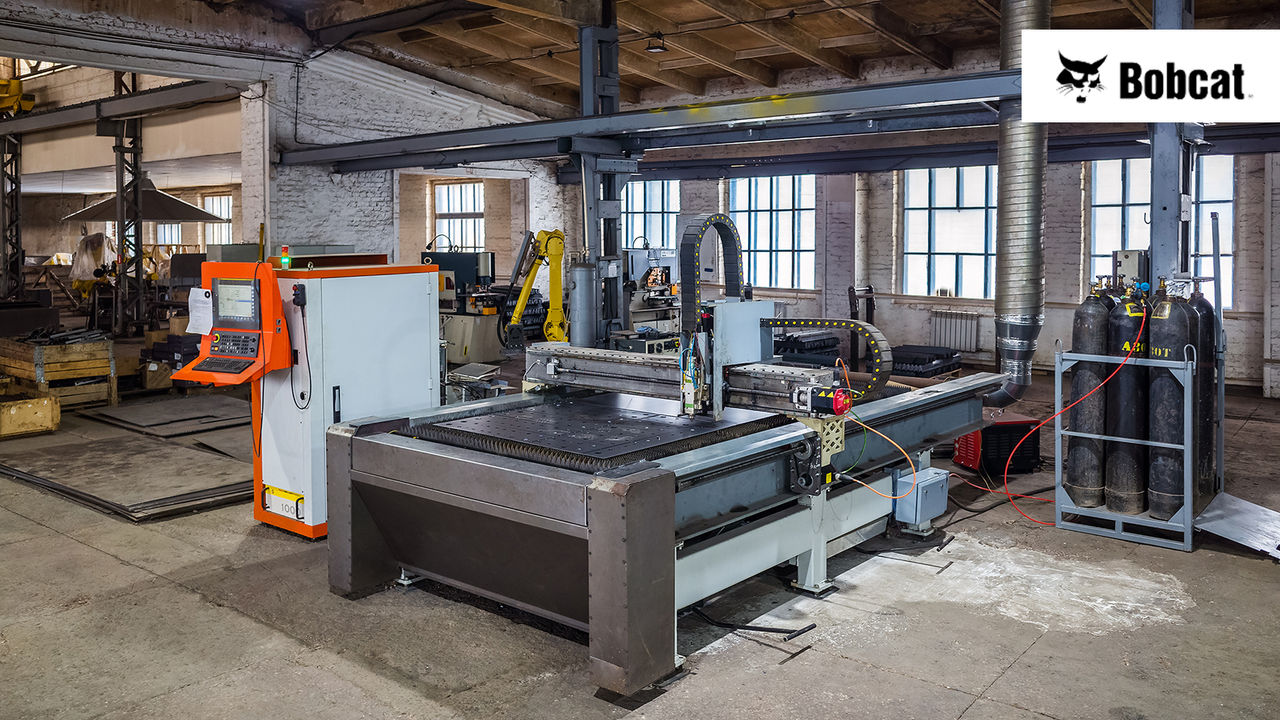 CNC laser cutting machine for sheet metal in the production area of a manufacturing plant with the Bobcat logo.