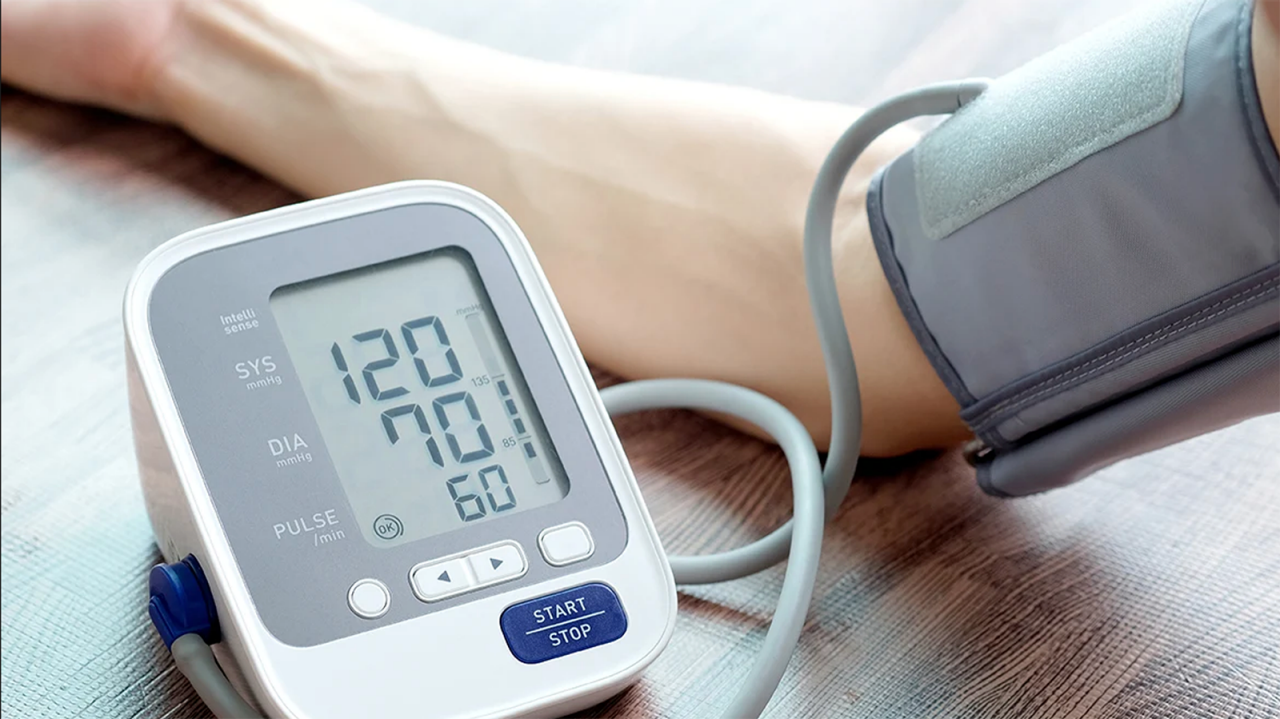 Modern blood pressure monitor getting a reading of a woman's arm.