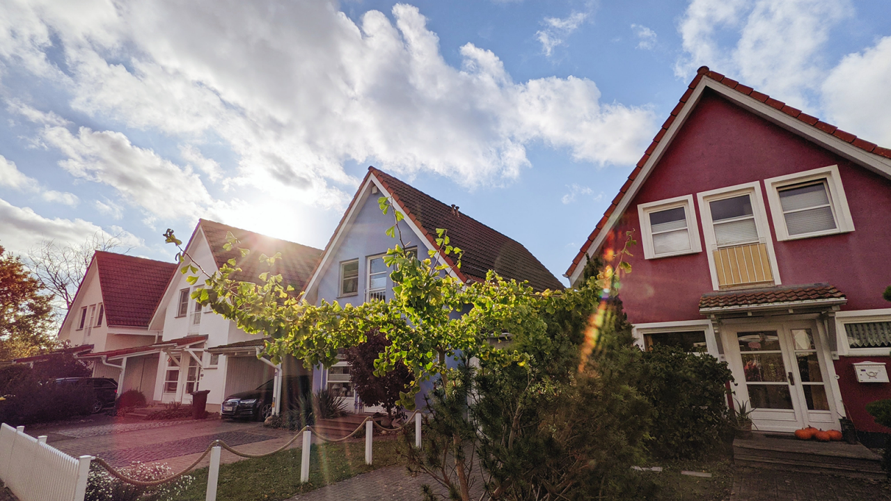 Four houses in the suburbs with the sun beaming over them.