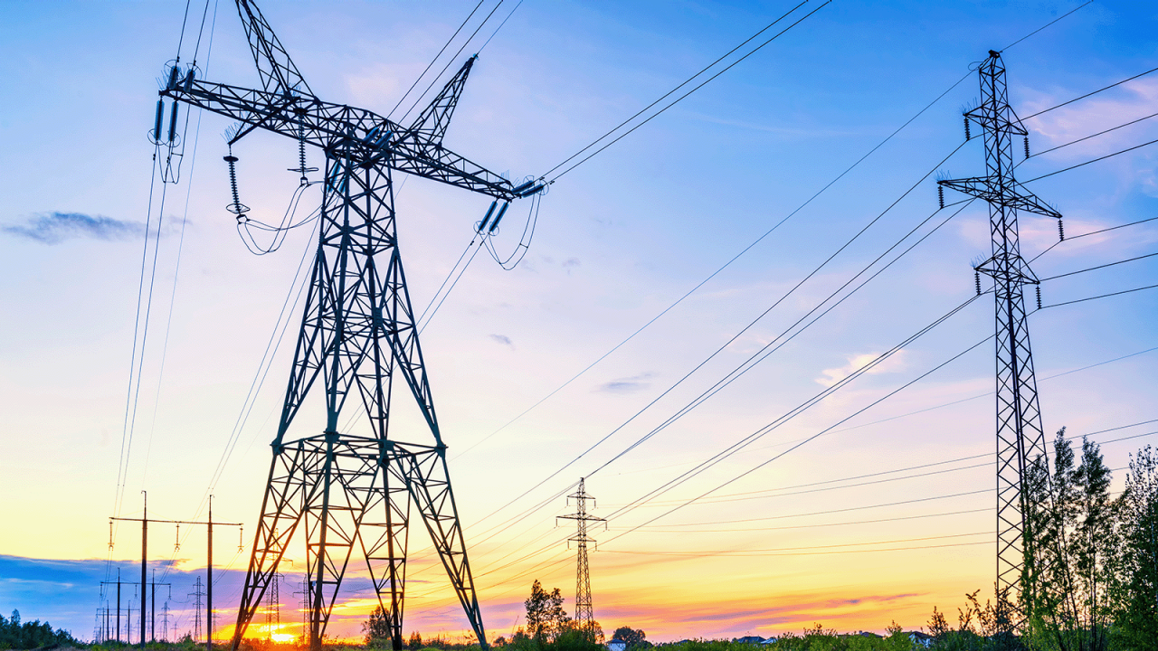 Landscape with high voltage powerlines with a sunset background.