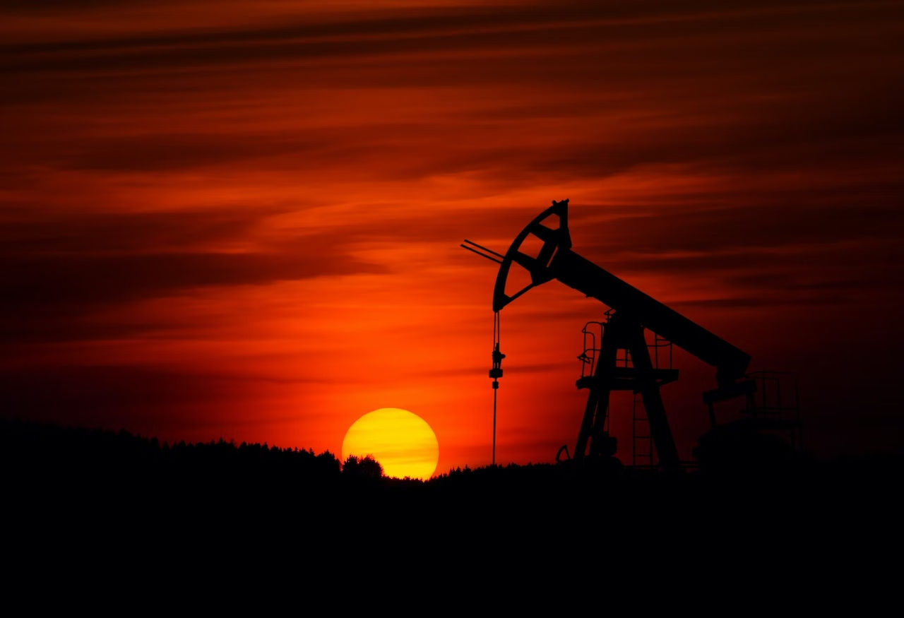 Un puits de pétrole avec un coucher de soleil en arrière-plan