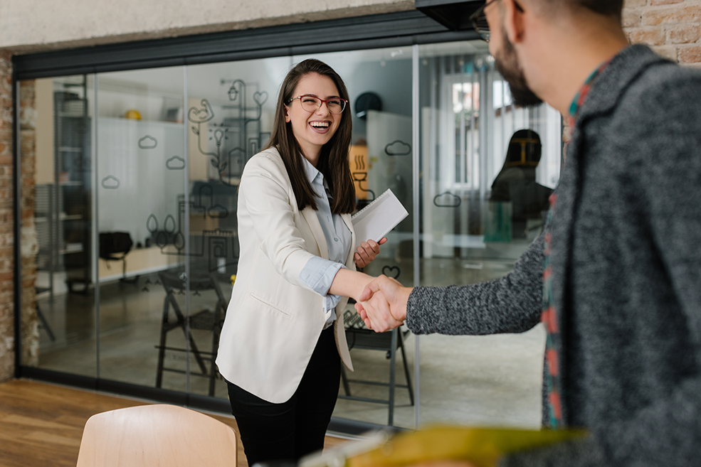 Smiling plainly and firmly handshaking with human resource manager